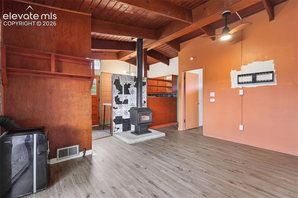 Image 13 of 36: Wood-finish flooring, exposed wood beam ceiling, contemporary ceiling fan w
