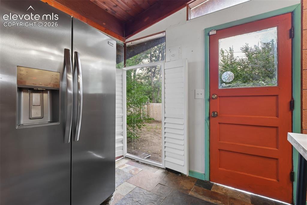 Image 14 of 36: Stainless steel side-by-side refrigerator, slate flooring, wood-paneled cei