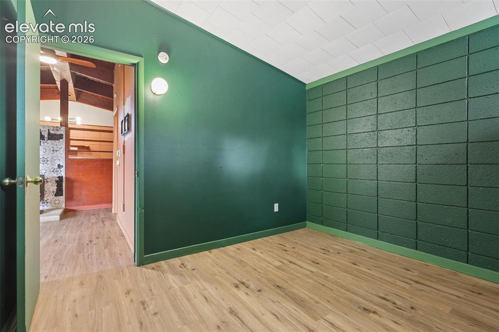 Image 21 of 36: Wood-finish flooring, accent wall with rectangular block texture, smooth pa