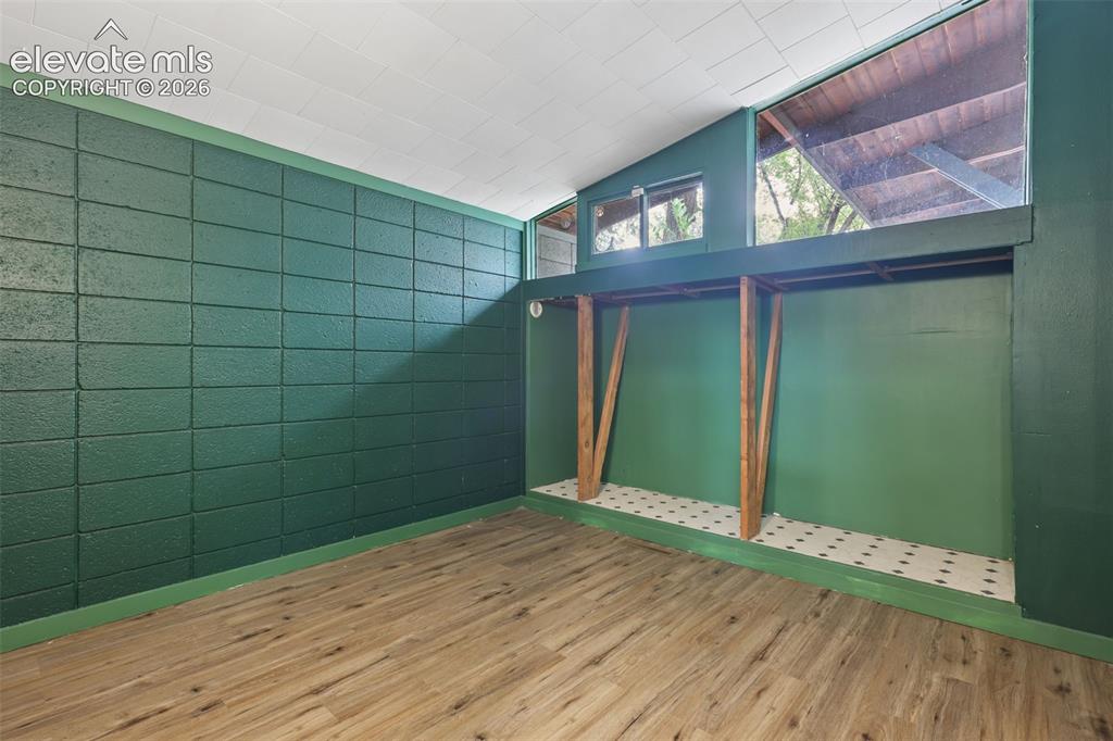 Image 22 of 36: Wood-finish flooring with a green accent wall and a built-in elevated platf