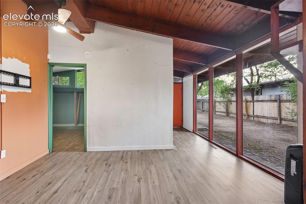 Image 9 of 36: Wood-finish flooring, exposed wood beam ceiling, full-height window panels,