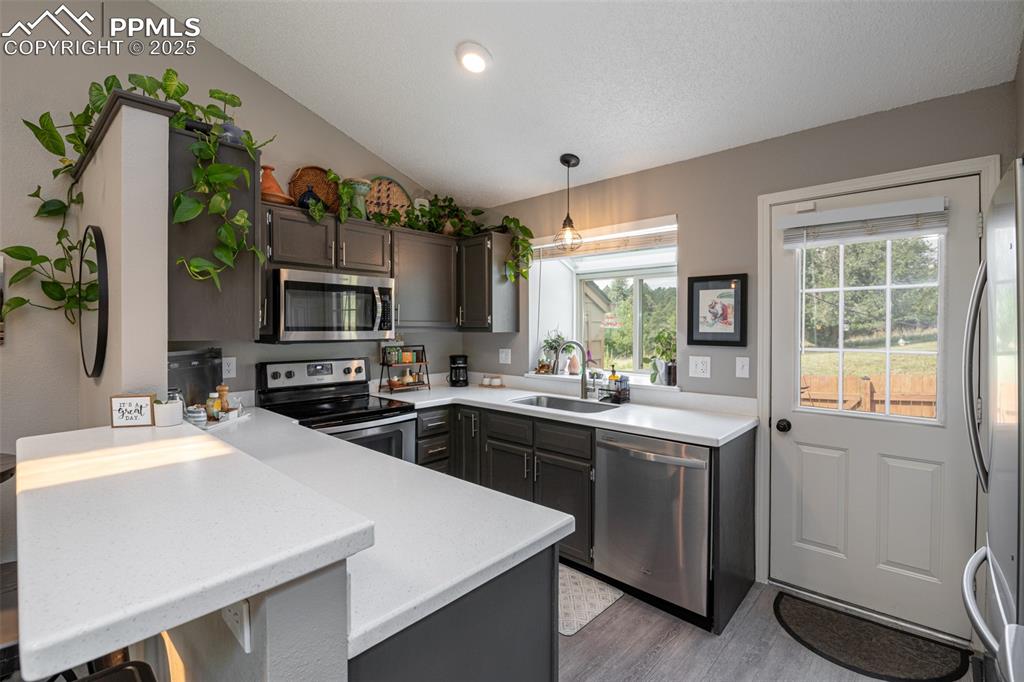 Image 10 of 27: Kitchen with breakfast bar, recessed lighting, appliances with stainless st