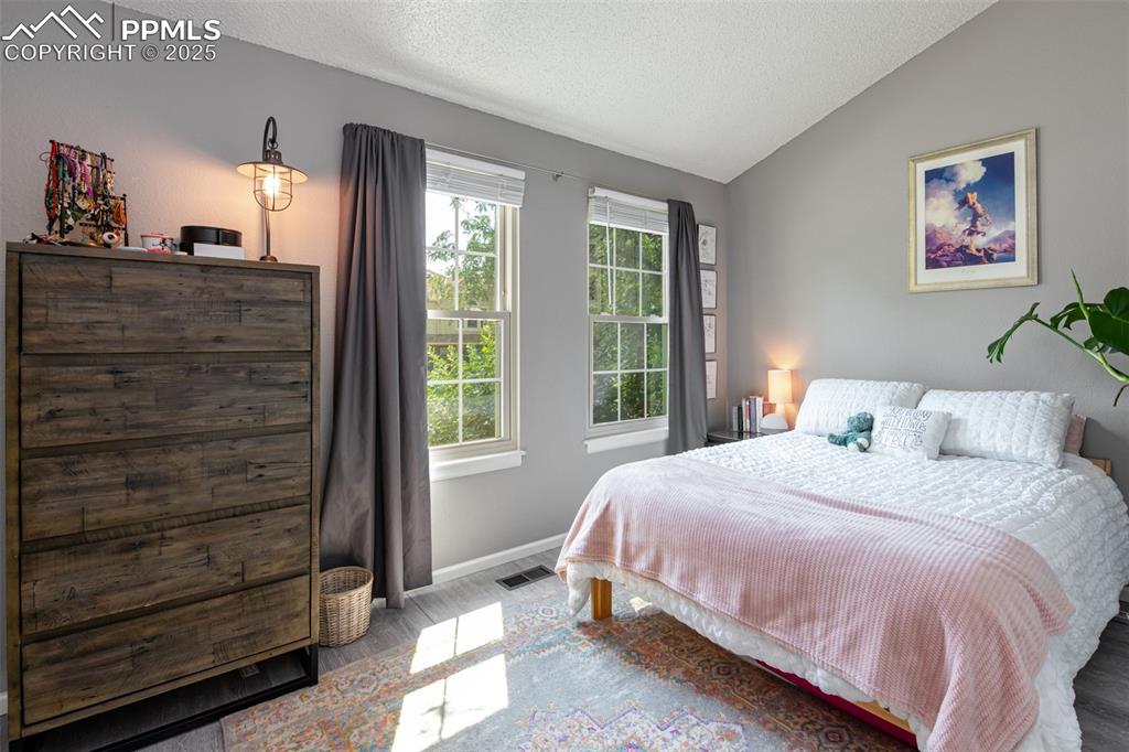 Image 15 of 27: Bedroom featuring new windows, blinds and black out curtains. View to the f
