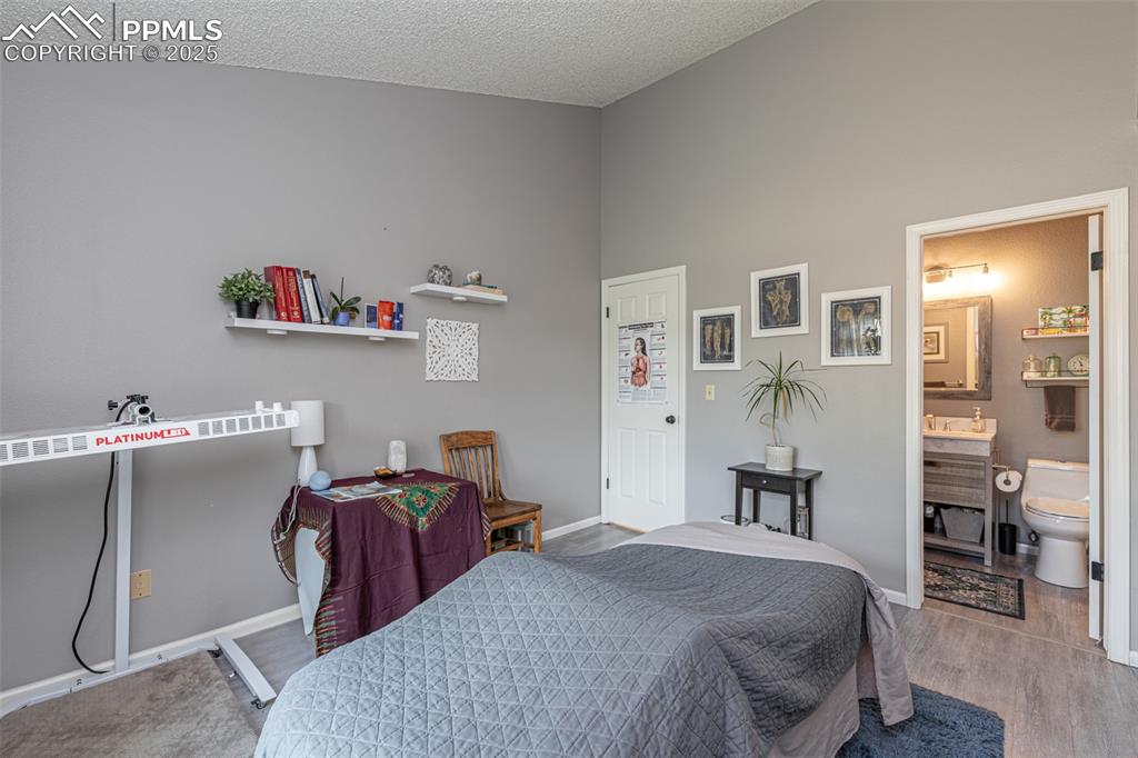 Image 18 of 27: Primary bedroom with door to bathroom.