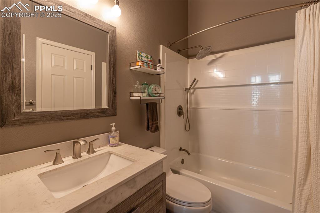 Image 19 of 27: New Shower/tub combo with great shelf, granite countertop, low flow toilet.