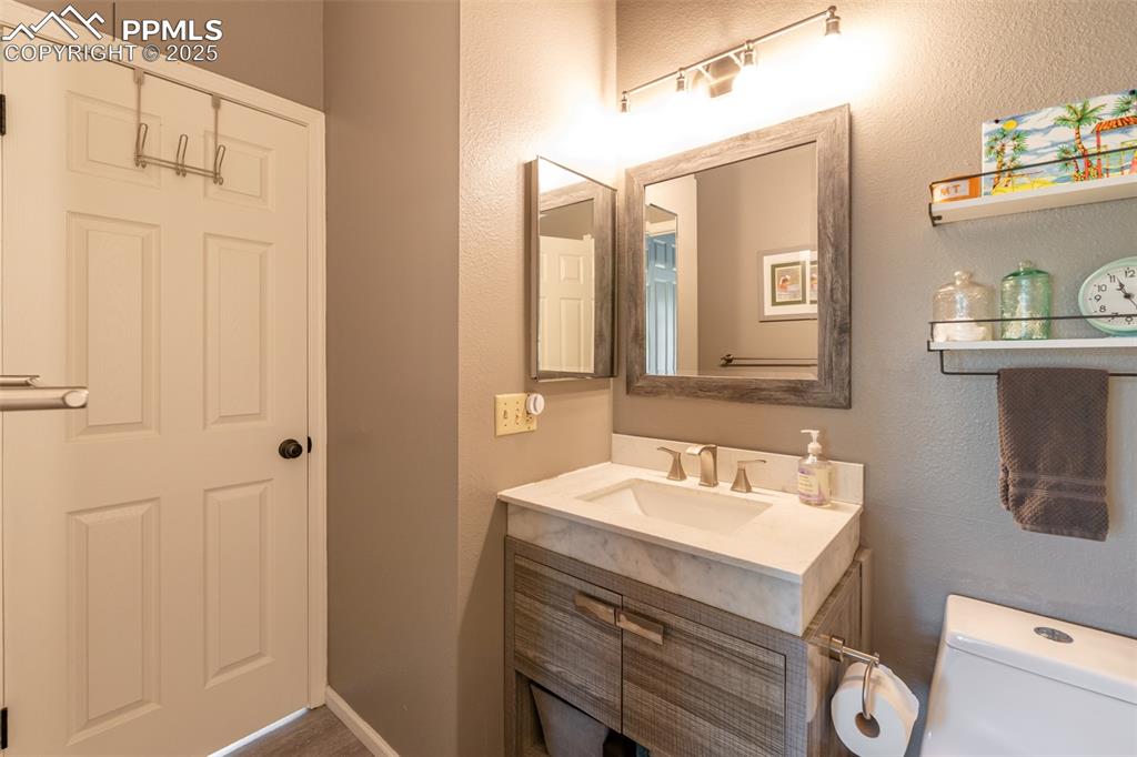 Image 20 of 27: Full bath featuring a vanity, updated lighting and low flow comode.