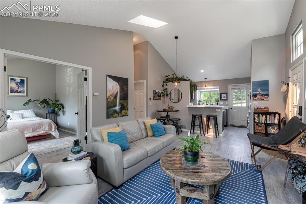 Image 9 of 27: Living room with french doors to one bedroom. Light colored paint througho