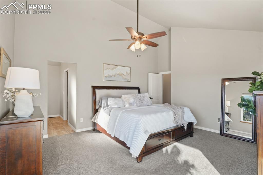 Image 20 of 37: Carpeted bedroom featuring high vaulted ceiling and ceiling fan