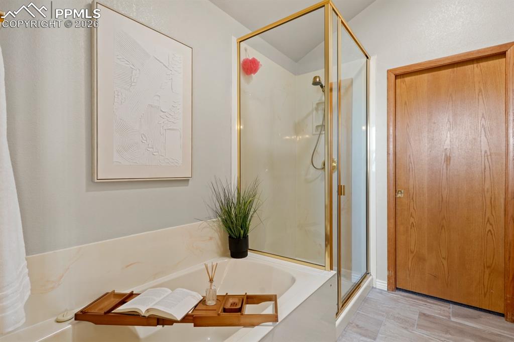Image 21 of 37: Bathroom featuring hardwood / wood-style flooring and plus walk in shower