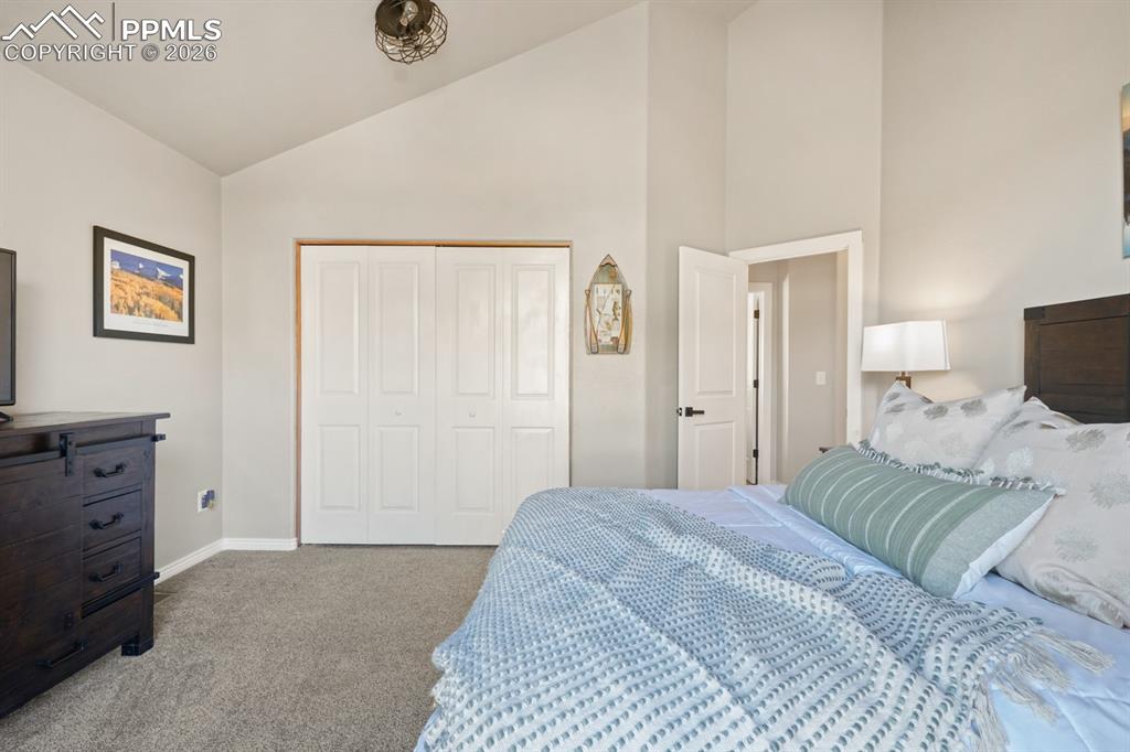 Image 24 of 37: Bedroom featuring a closet, high vaulted ceiling, and carpet floors