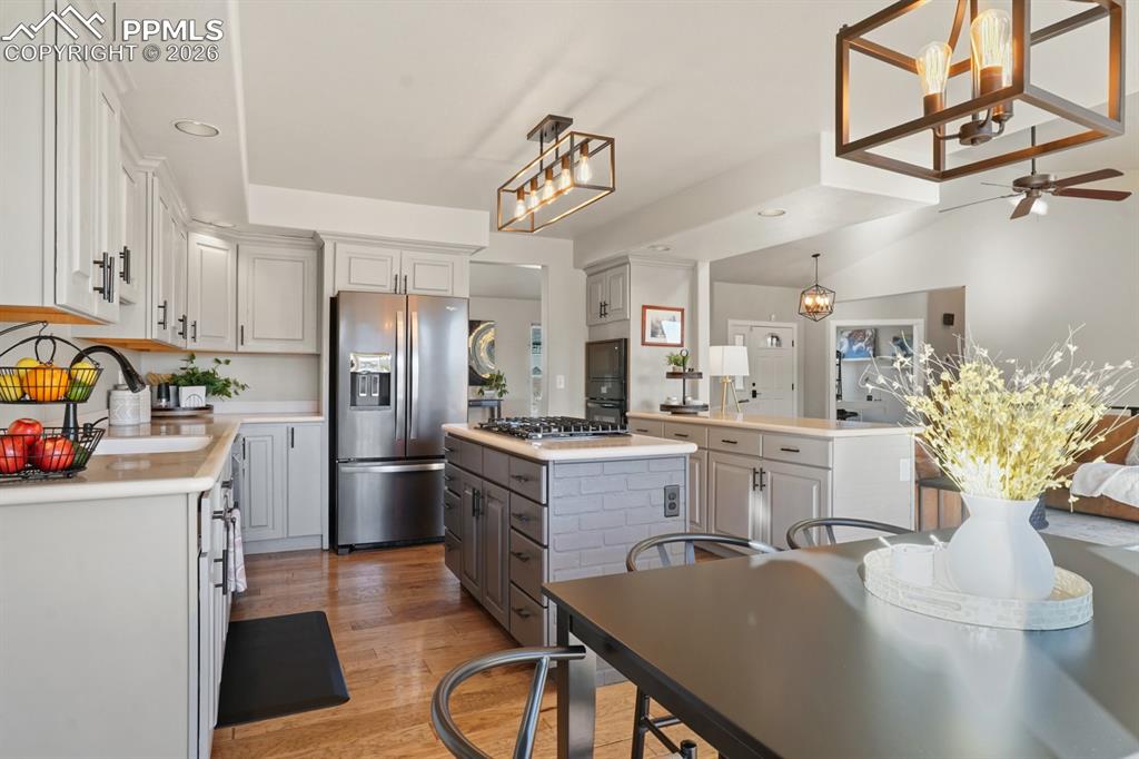 Image 9 of 37: Kitchen with gray cabinets, stainless steel appliances, wood-type flooring,