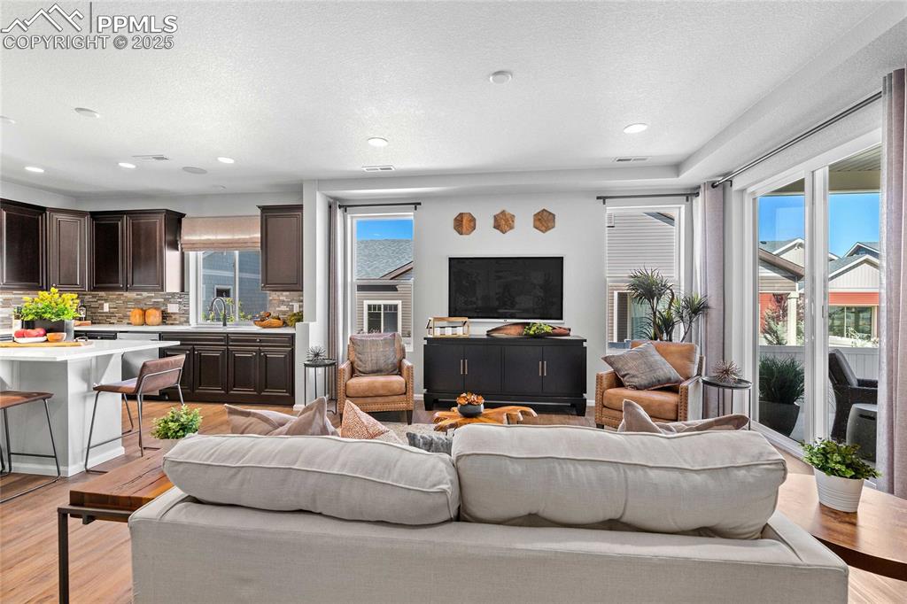 Image 10 of 27: Living room with light wood-type flooring, recessed lighting, and a texture