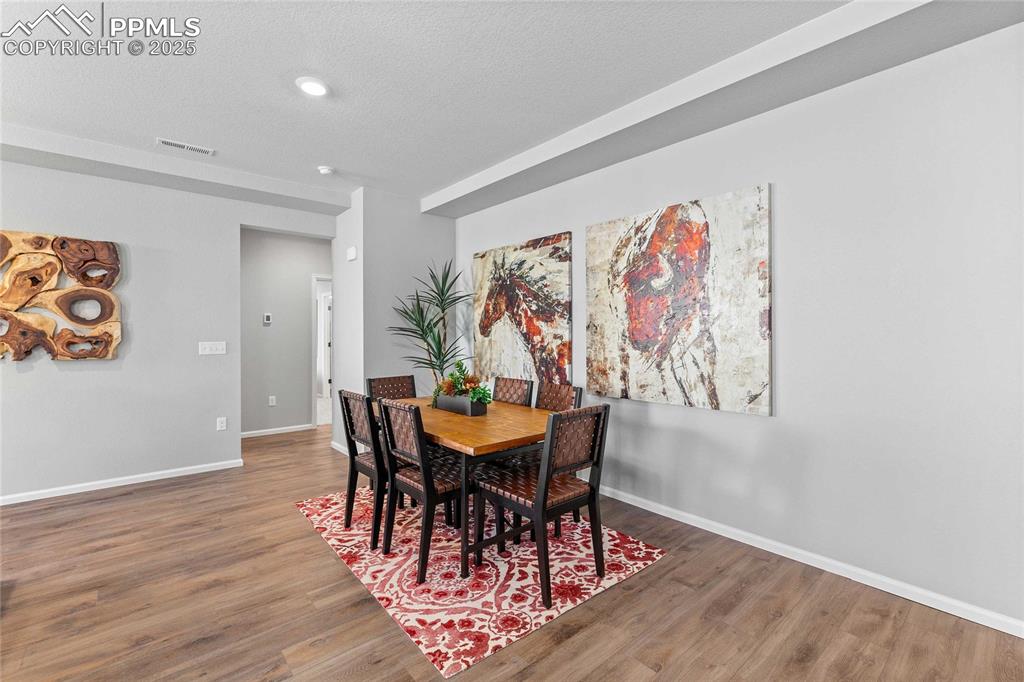 Image 2 of 27: Dining space featuring wood finished floors and a textured ceiling