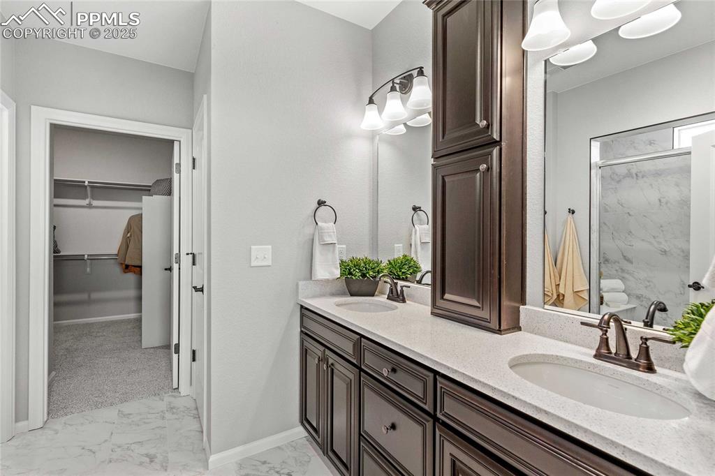Image 20 of 27: Full bathroom featuring a spacious closet, double vanity, light marble fini