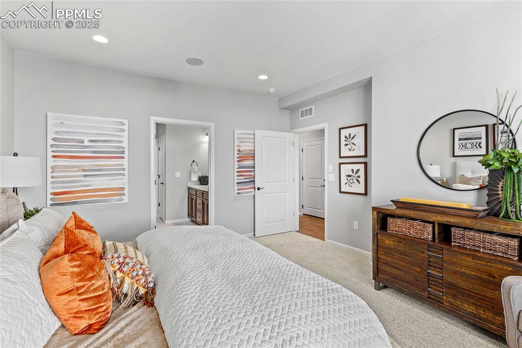 Image 23 of 27: Bedroom with carpet, ensuite bath, and recessed lighting