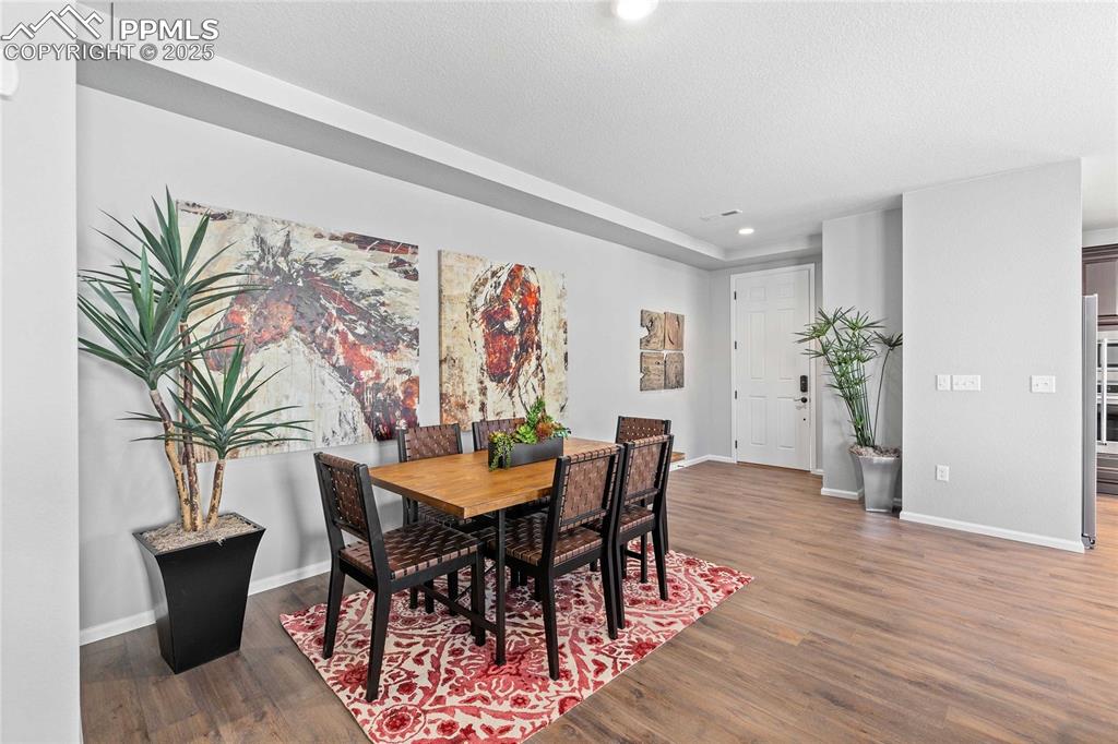Image 3 of 27: Dining space with dark wood-type flooring, recessed lighting, and a texture