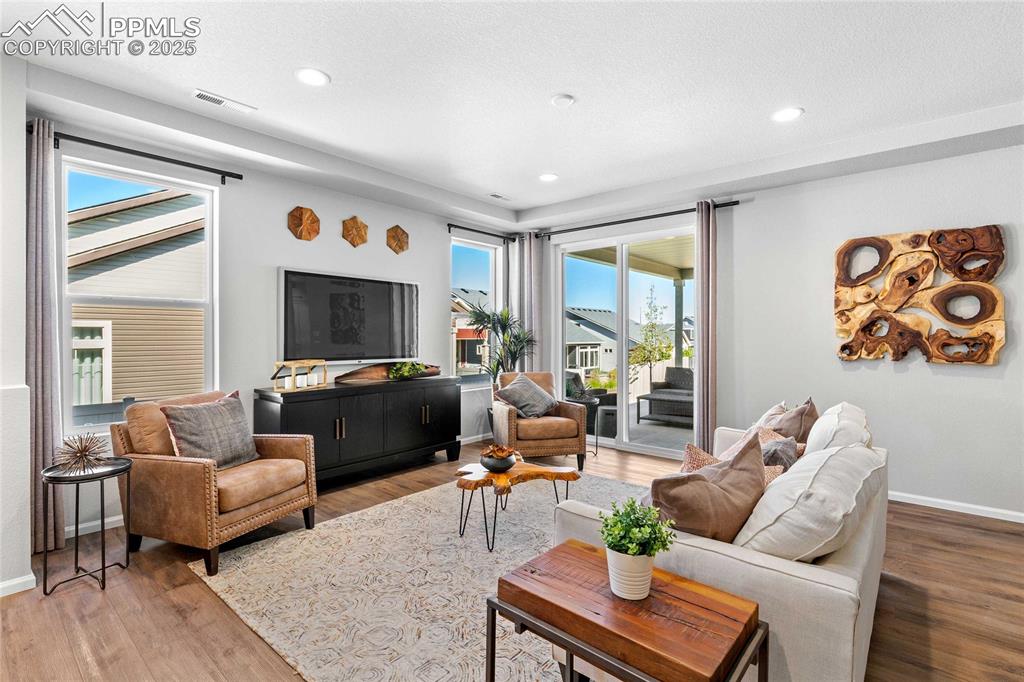 Image 5 of 27: Living area featuring wood finished floors, recessed lighting, and stairway