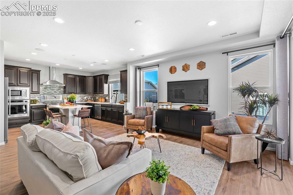 Image 7 of 27: Living room with light wood-style floors and recessed lighting