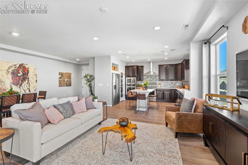 Image 8 of 27: Living room featuring light wood-type flooring and recessed lighting