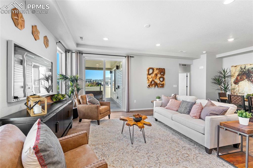 Image 9 of 27: Living room with light wood-style flooring and recessed lighting