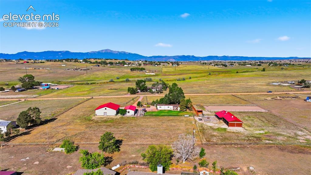 Image 12 of 50: Expansive rural property featuring multiple structures, open fields, and di