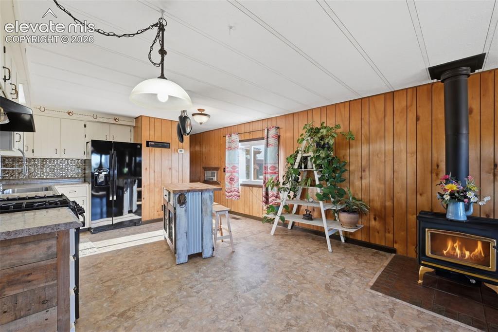 Image 24 of 50: Wood paneling and white ceiling planks complement wood-finish flooring