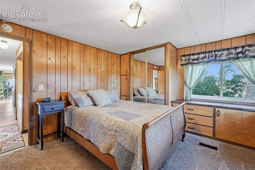Image 28 of 50: Wood-paneled walls and a window with outdoor scenery