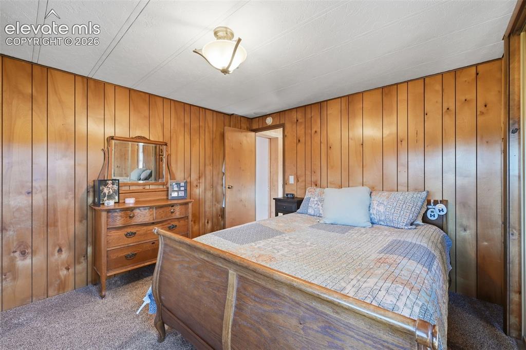 Image 29 of 50: Wood-paneled walls with a textured ceiling and a built-in light fixture