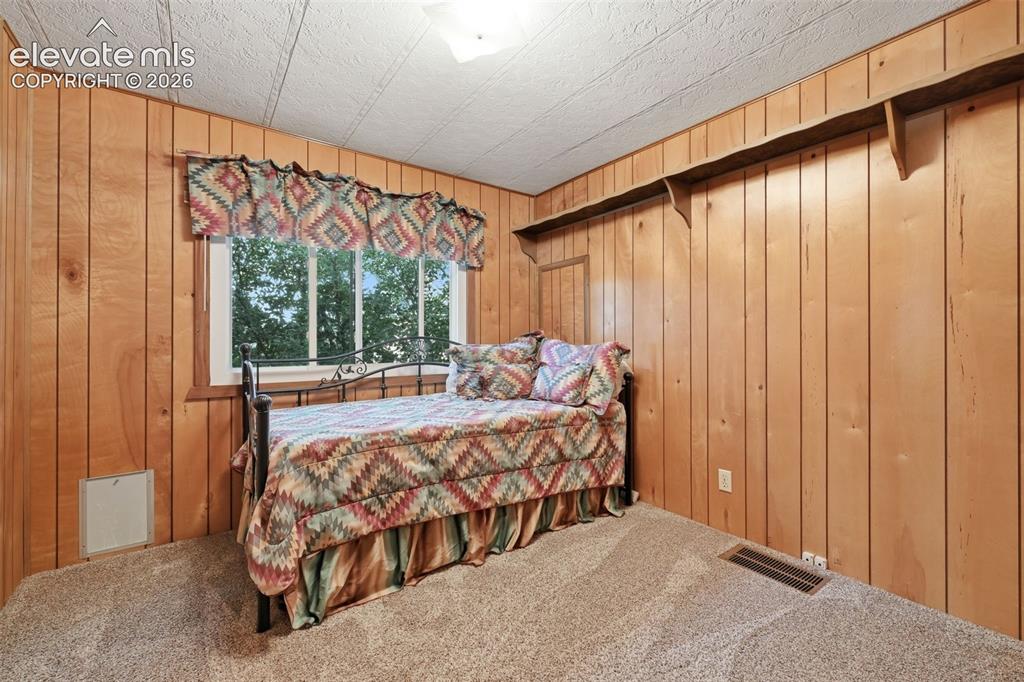Image 32 of 50: Wood-paneled walls with textured ceiling