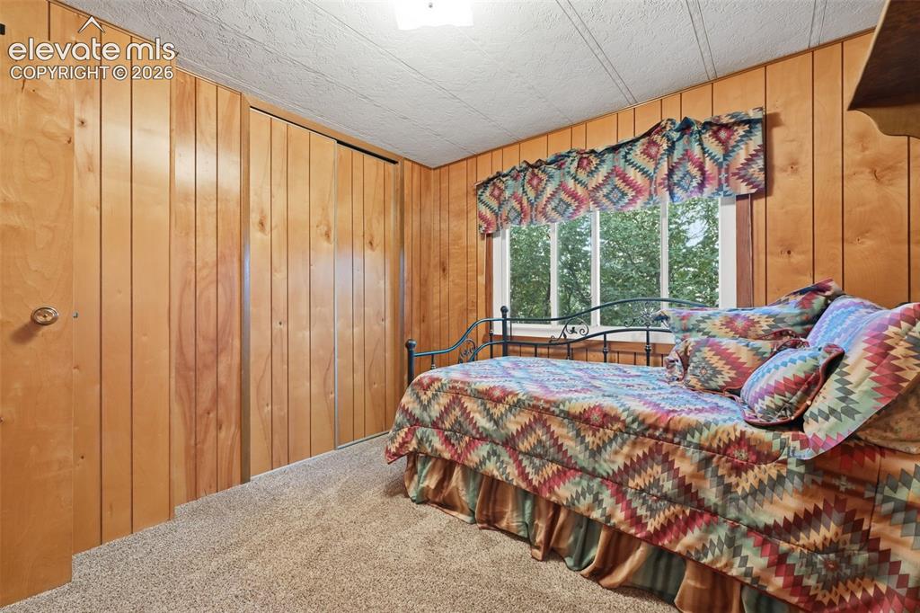 Image 33 of 50: Wood-paneled walls and a window with white trim