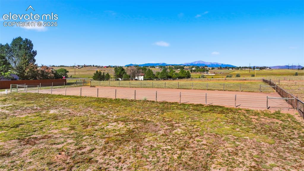 Image 8 of 50: Expansive outdoor arena with post and rail fencing, surrounded by open land