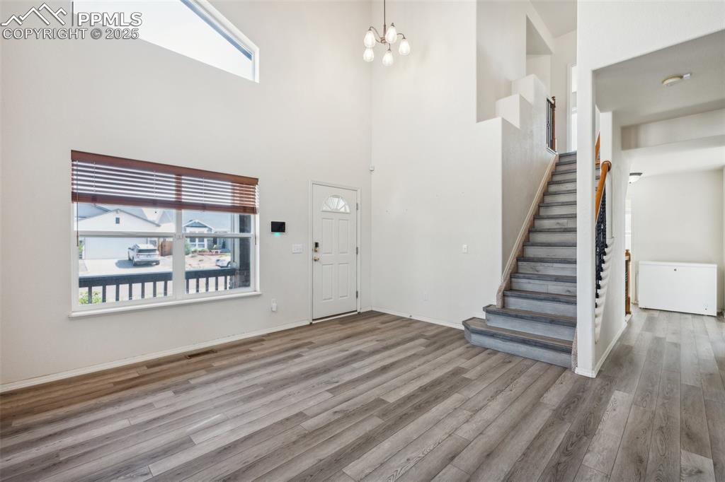 Image 11 of 38: Foyer with wood finished floors, healthy amount of natural light, stairway,