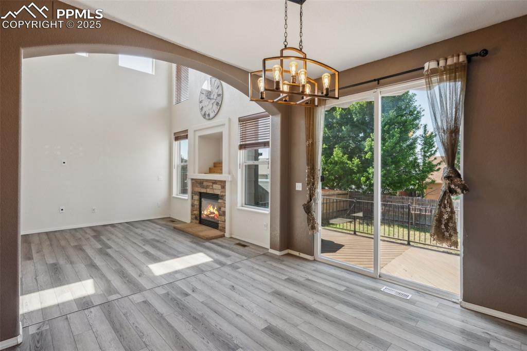 Image 16 of 38: Unfurnished dining area with arched walkways, a chandelier, wood finished f