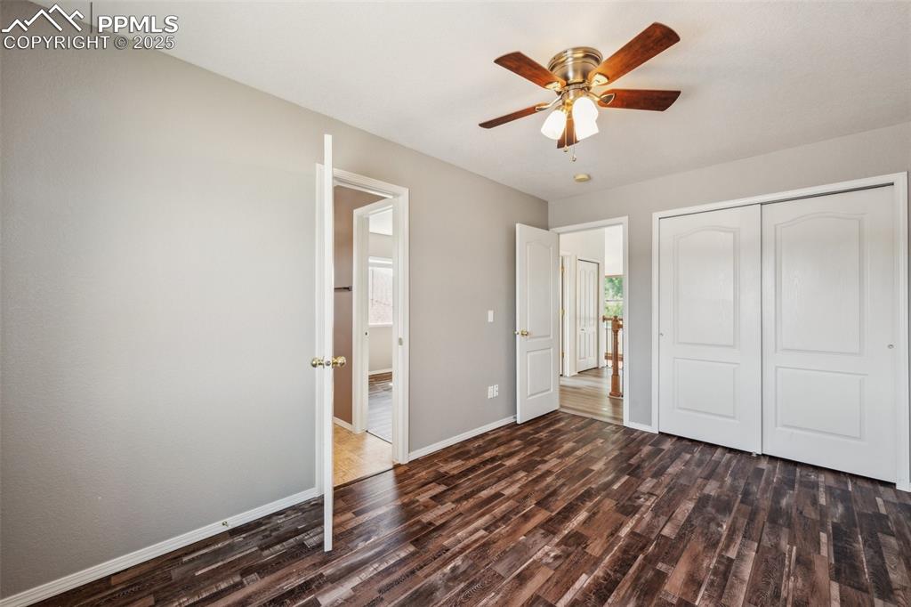 Image 24 of 38: Unfurnished bedroom with dark wood-type flooring, a closet, and ceiling fan
