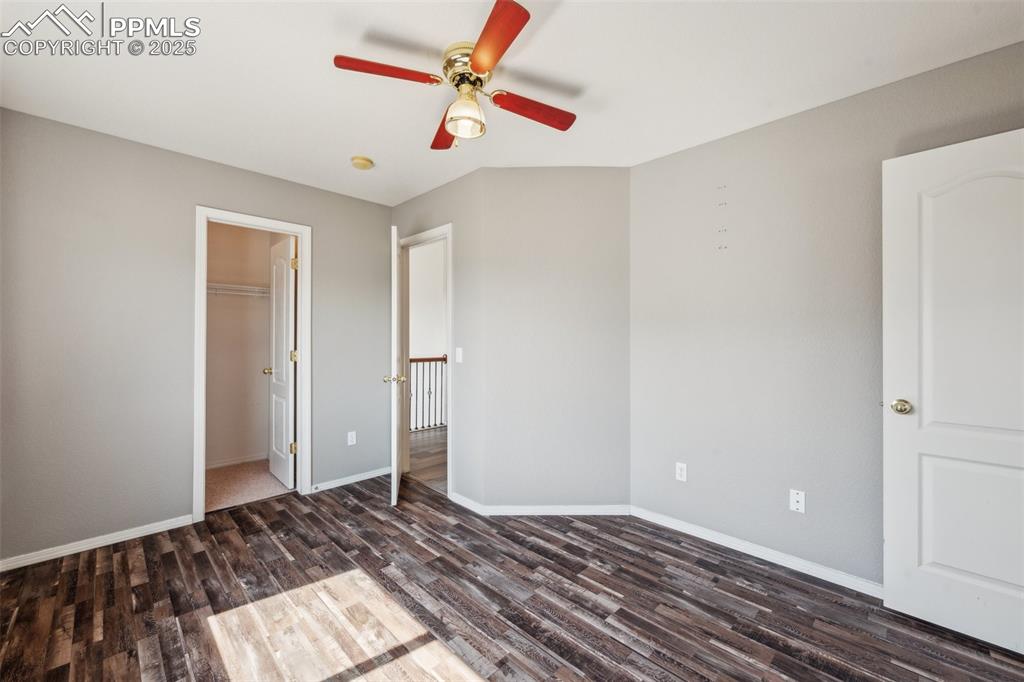 Image 26 of 38: Unfurnished bedroom featuring wood finished floors, a ceiling fan, and a wa