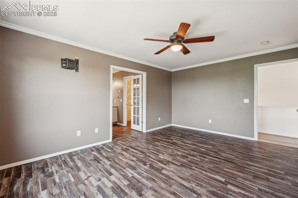 Image 29 of 38: Unfurnished room with ceiling fan, dark wood-style flooring, and ornamental
