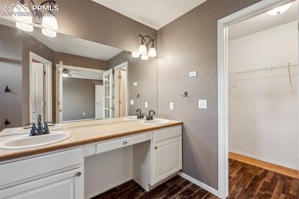 Image 31 of 38: Full bath featuring wood finished floors, double vanity, a textured wall, a