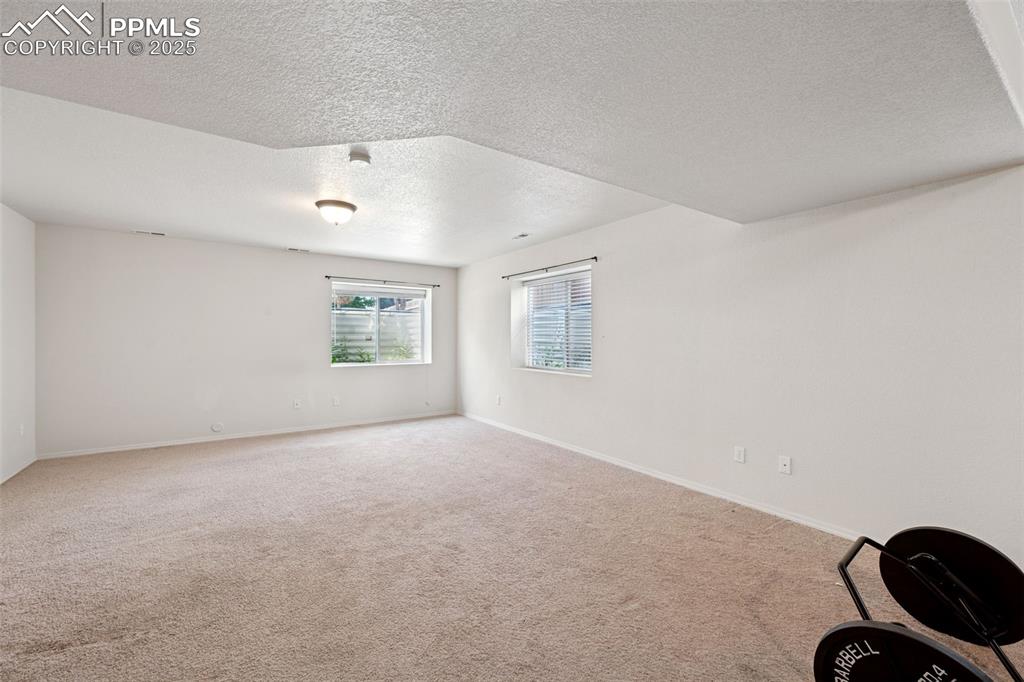 Image 33 of 38: Spare room featuring a textured ceiling and carpet flooring