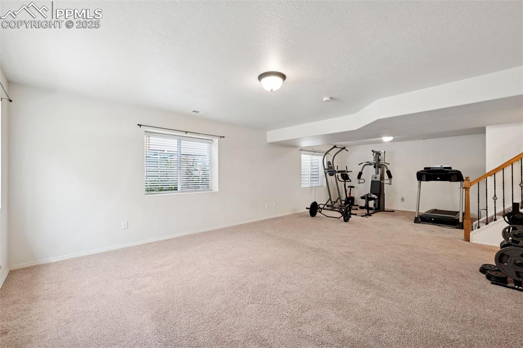 Image 34 of 38: Workout room featuring carpet floors and a textured ceiling