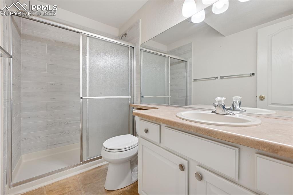 Image 38 of 38: Full bathroom with vanity, a stall shower, and tile patterned floors