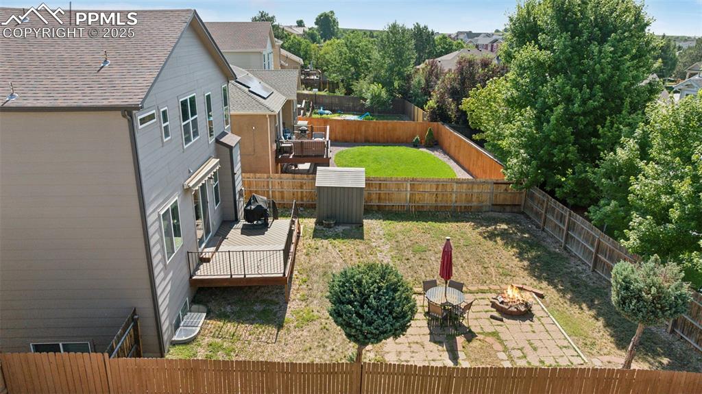 Image 6 of 38: Fenced backyard featuring an outdoor fire pit and a deck