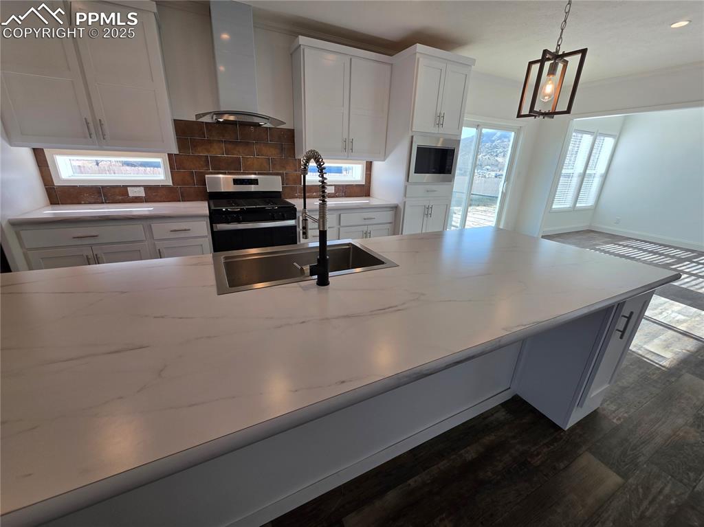 Image 13 of 25: Kitchen featuring white cabinetry, stainless steel appliances, ventilation