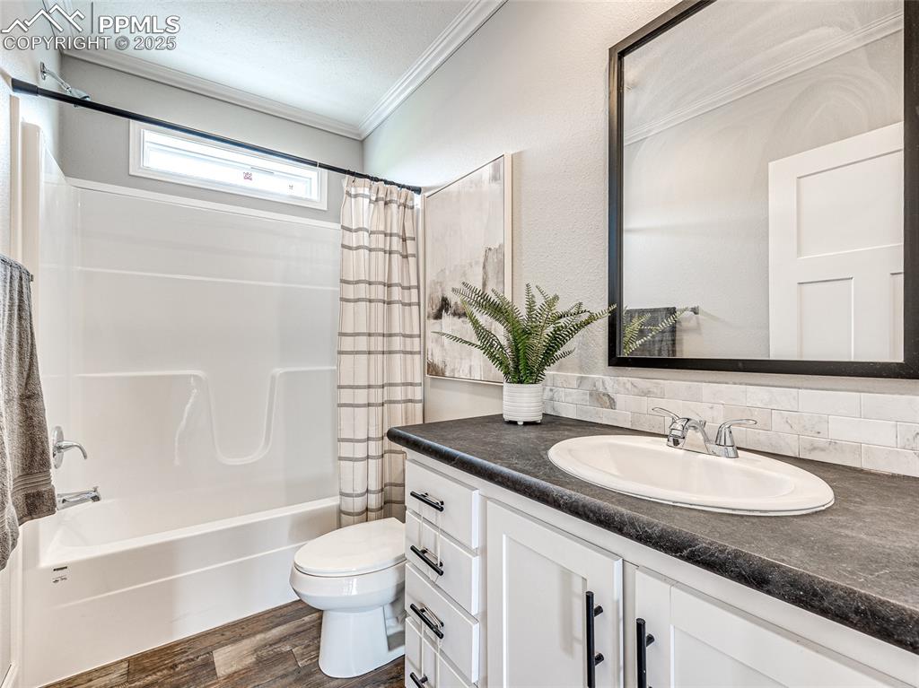 Image 18 of 25: Bathroom featuring ornamental molding, vanity, shower / bath combo with sho