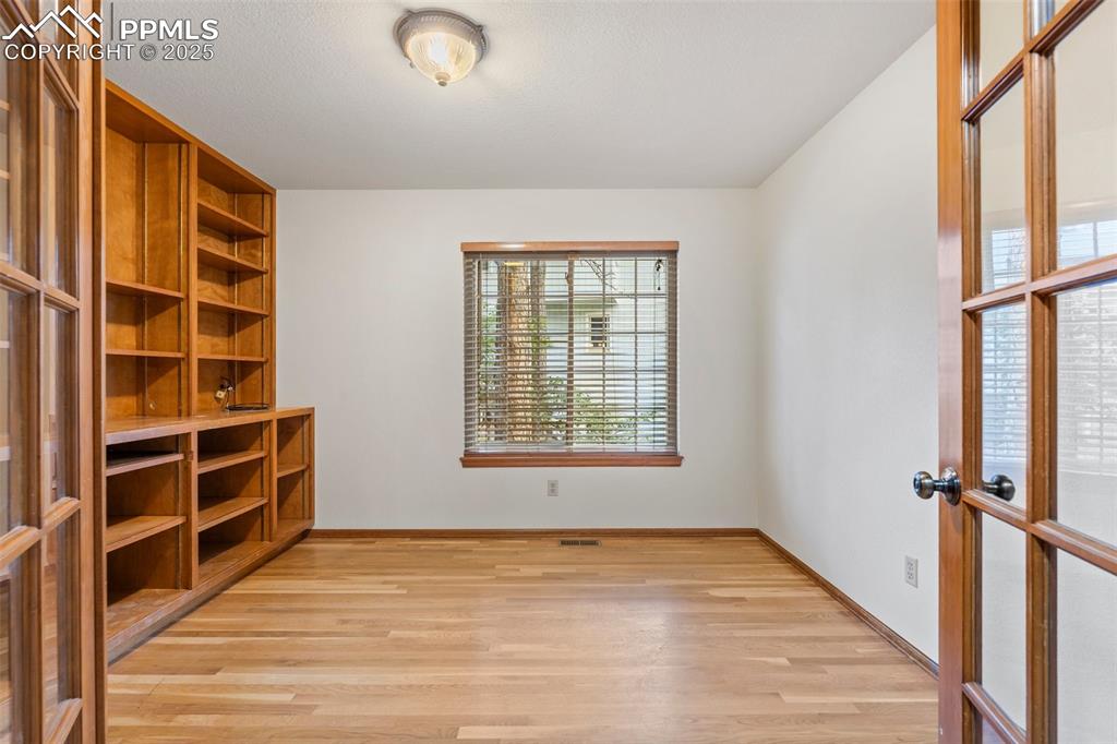 Image 13 of 26: Spare room featuring light wood-type flooring and french doors
