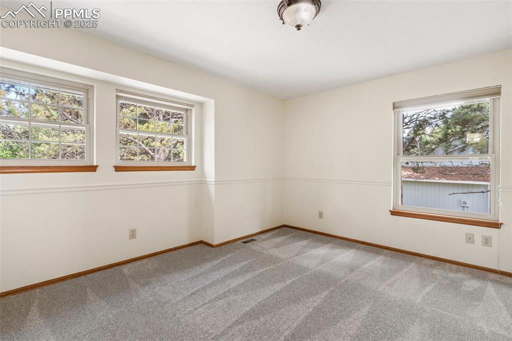 Image 18 of 26: Unfurnished room featuring healthy amount of natural light and carpet floor