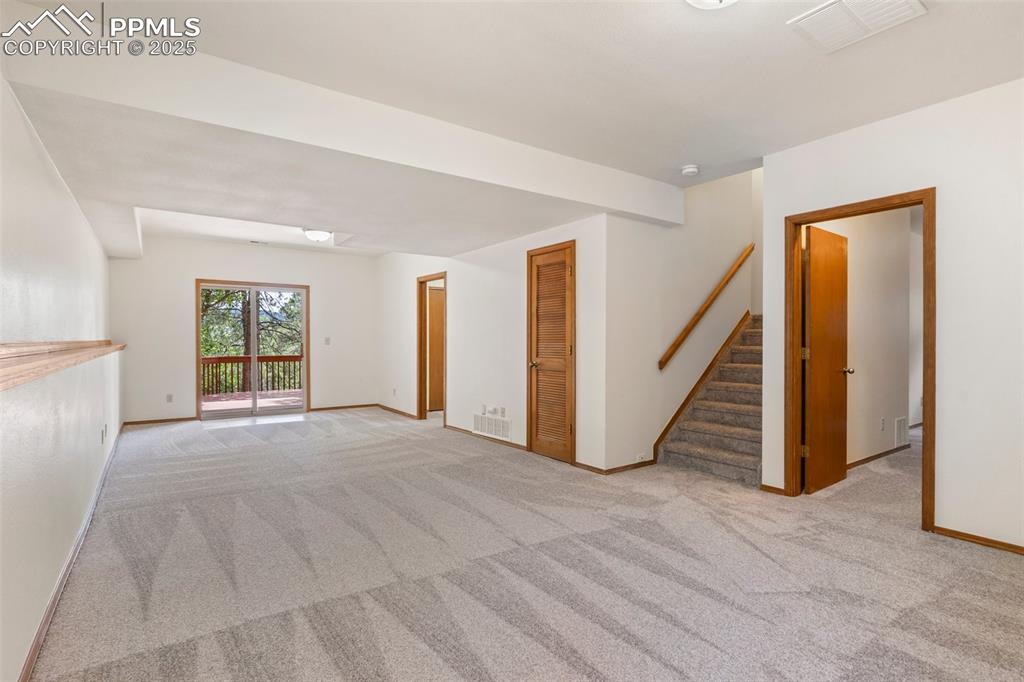Image 20 of 26: Carpeted spare room with stairs and a smoke detector