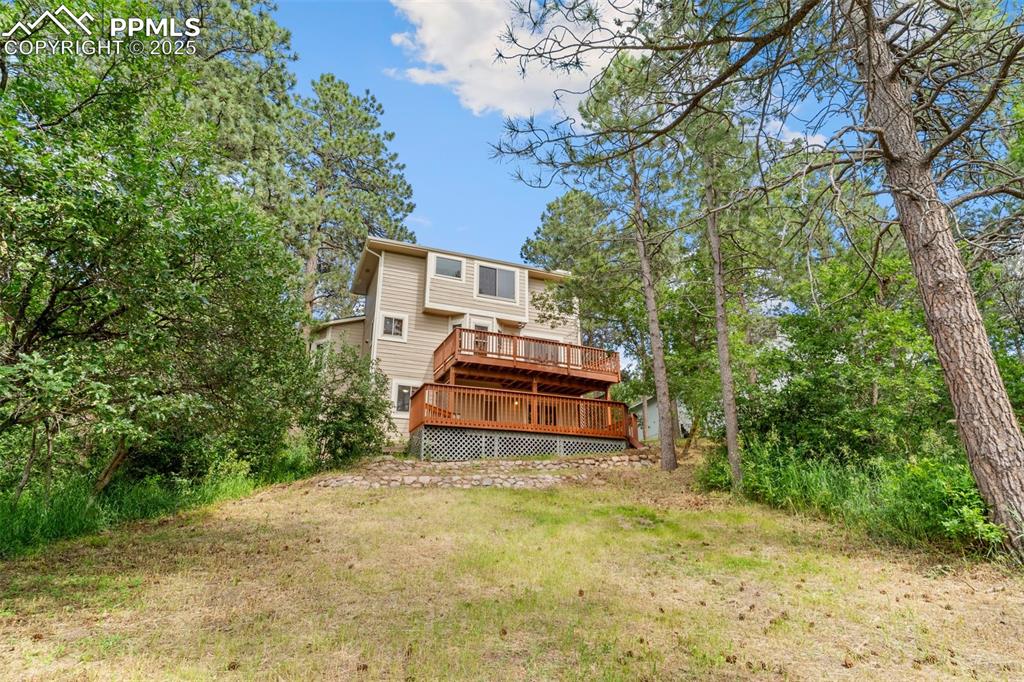 Image 26 of 26: Back of property with a wooden deck and a lawn