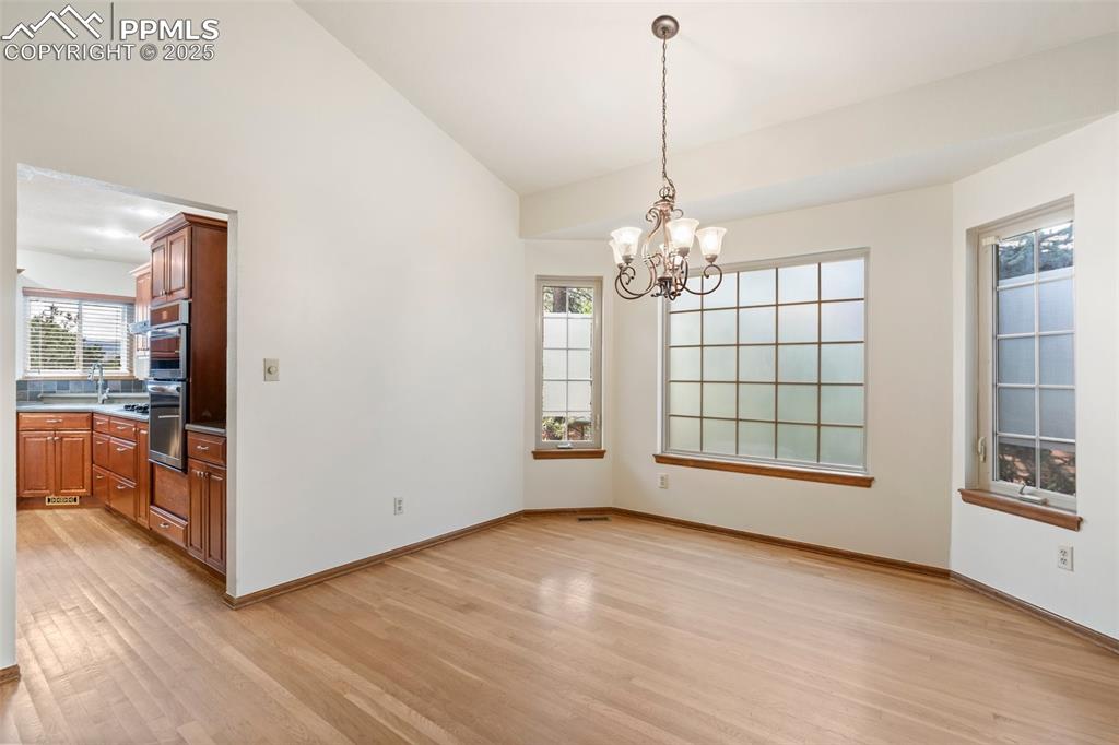 Image 5 of 26: Unfurnished dining area with light wood finished floors, a chandelier, and