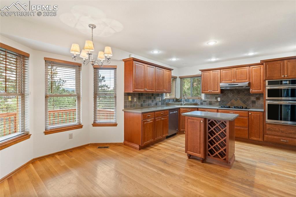 Image 8 of 26: Kitchen featuring stainless steel appliances, under cabinet range hood, a c