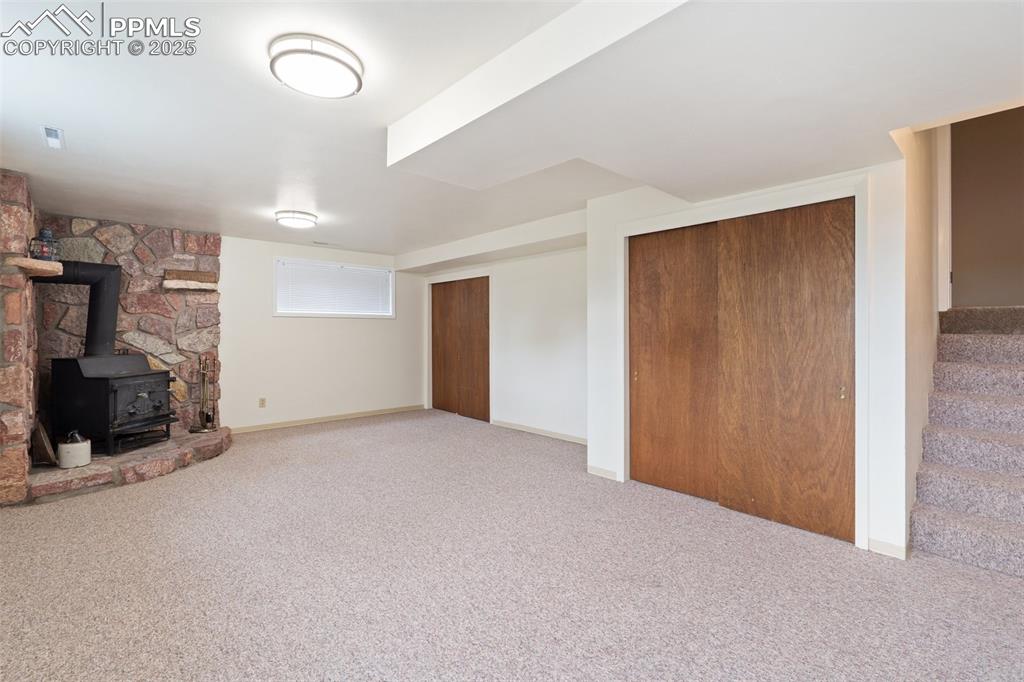 Image 34 of 50: Basement rec room w/woodburning stove